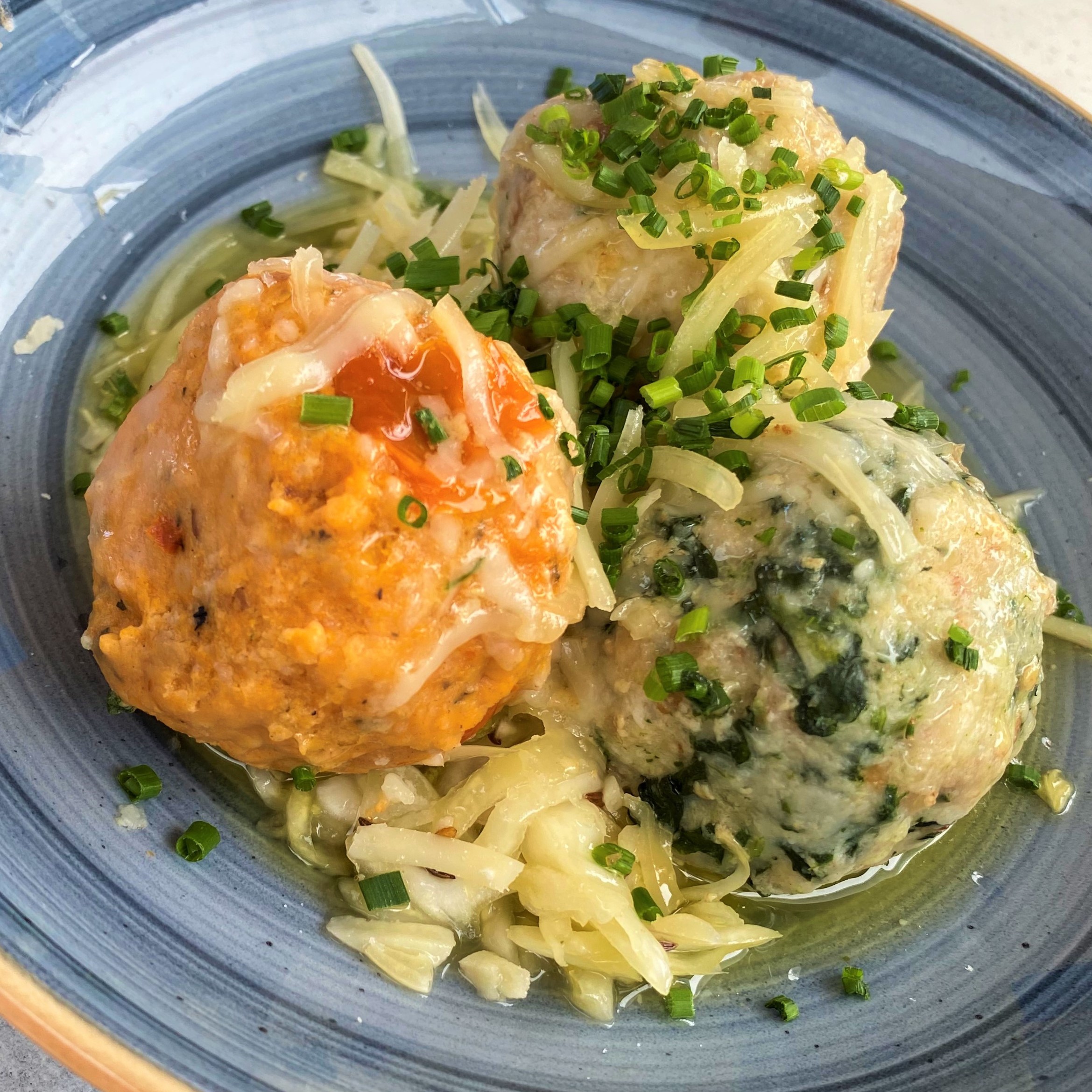 Dreierlei Knödel (Spinat, Käse, Tomate) mit zerlassener Butter und Parmesan